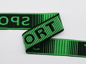 Gros plan sur un élastique jacquard vert et noir de grande qualité, orné de l'inscription « SPORT », mettant en valeur la texture du tissu de la ceinture.